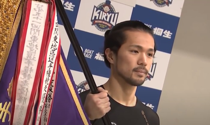 初優勝のフラッグを持つ今泉友吾